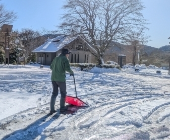 ビジターセンターの駐車場を雪かきしている様子　
